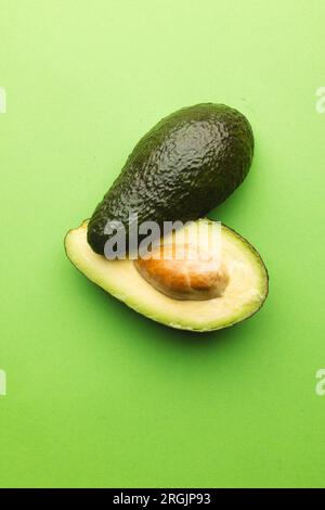 Primo piano di due metà di avocado e spazio di copia su sfondo verde Foto Stock