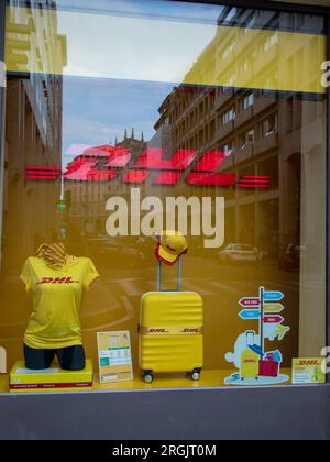 Milano , Italia - 08 07 2023 : DHL deutsche post Group testo logo e marchio giallo in finestre accessori gadget pubblicitari in facciata boutiq Foto Stock