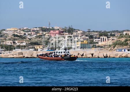 Lampedusa, Sicilia, provincia di Agrigento, i migranti sbarcarono nel porto di Lampedusa. Un peschereccio tunisino di nome Montacer II atterra con un gruppo di migranti ha salvato poche miglia al largo di Lampedusa. Foto Stock