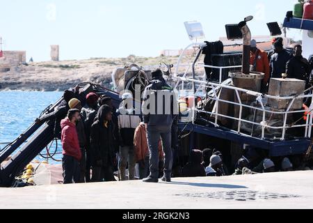 Lampedusa, Sicilia, provincia di Agrigento, i migranti sbarcarono nel porto di Lampedusa. Un peschereccio tunisino di nome Montacer II atterra con un gruppo di migranti ha salvato poche miglia al largo di Lampedusa. Foto Stock