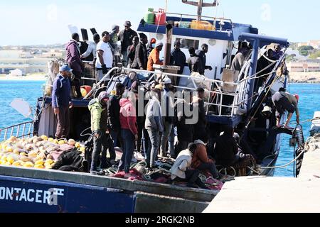 Lampedusa, Sicilia, provincia di Agrigento, i migranti sbarcarono nel porto di Lampedusa. Un peschereccio tunisino di nome Montacer II atterra con un gruppo di migranti ha salvato poche miglia al largo di Lampedusa. Foto Stock