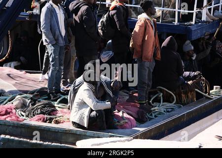 Lampedusa, Sicilia, provincia di Agrigento, i migranti sbarcarono nel porto di Lampedusa. Un peschereccio tunisino di nome Montacer II atterra con un gruppo di migranti ha salvato poche miglia al largo di Lampedusa. Foto Stock