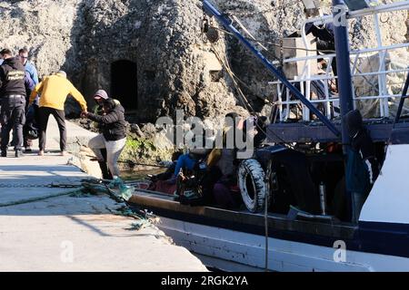 Lampedusa, Sicilia, provincia di Agrigento, i migranti sbarcarono nel porto di Lampedusa. Un peschereccio tunisino di nome Montacer II atterra con un gruppo di migranti ha salvato poche miglia al largo di Lampedusa. Foto Stock