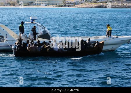 Lampedusa, Sicilia, provincia di Agrigento, i migranti sbarcarono nel porto di Lampedusa. Un peschereccio tunisino di nome Montacer II atterra con un gruppo di migranti ha salvato poche miglia al largo di Lampedusa. Foto Stock