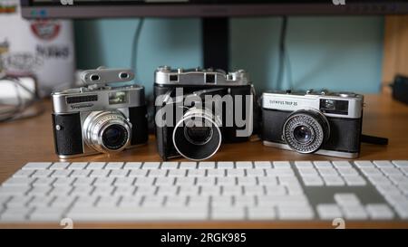 Trio di fotocamere d'epoca giustapposte alla tecnologia moderna Foto Stock