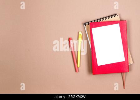 Quaderno scolastico e cancelleria di vario genere su sfondo beige. Provviste per studiare a scuola. Flatlay, un trucco. Cornice di cancelleria colorata. Torna a. Foto Stock
