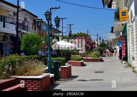 Kassandreia, Grecia - 8 giugno 2023: Penisola di Kassandra in Halkidiki, gruppo non identificato di giovani nella zona pedonale con una parte centrale verde e va Foto Stock