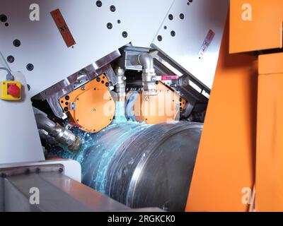 una macchina di fabbrica funziona, mentre i suoi sistemi di raffreddamento la raffreddano con un liquido blu Foto Stock