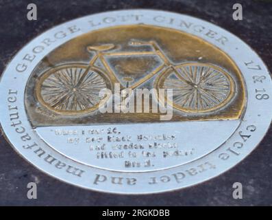 Bronzo e acciaio su Parson's Street a Banbury, segnando la sede del negozio di George Lott, commerciante e produttore di biciclette Foto Stock