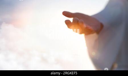 Gesù Cristo a braccia aperte che si estendono nel cielo, gesti della mano di Gesù che muore sulla croce e risorto, cielo e salvezza, fede e amore, Foto Stock