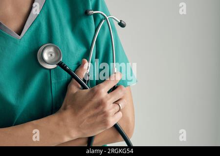 Crop medico irriconoscibile in uniforme medica con stetoscopio professionale fatto di metallo e materiali di gomma Foto Stock