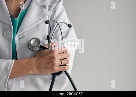 Crop donna irriconoscibile medico in bianco accappatoio medico con acciaio inossidabile e stetoscopio di gomma di giorno Foto Stock