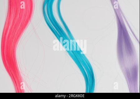 Tre ciocche di capelli colorate isolate su uno sfondo bianco dello studio Foto Stock