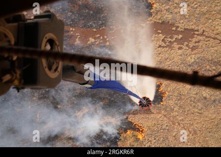 Maui, Stati Uniti. 9 agosto 2023. Un elicottero CH47 Chinook della Guardia Nazionale delle Hawaii esegue delle gocce aeree di secchi d'acqua su incendi che bruciano, il 9 agosto 2023 a Maui, Hawaii. Gli incendi alimentati da forti venti hanno ucciso almeno 36 persone e distrutto migliaia di case sull'isola. Credito: MSgt. Andrew Jackson/US Air Force Photo/Alamy Live News Foto Stock