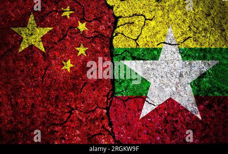 Cina e Myanmar hanno dipinto bandiere sul muro con texture grunge. Conflitto tra Cina e Myanmar. Cina contro Myanmar Foto Stock