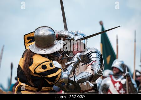 I reattori vestiti come cavalieri combattono con le spade nella rievocazione della Battaglia di Tewkesbury (4 maggio 1471) a Tewkesbury, Gloucestershire. Foto Stock