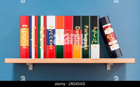 Libreria con libri di testo o dizionari di lingua, rendering 3D su parete blu Foto Stock