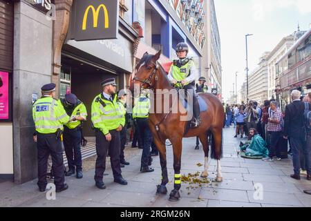 Londra, Regno Unito. 9 agosto 2023. Un agente di polizia a cavallo disperde la folla su Oxford Street. Secondo quanto riferito, un post sui social media ha organizzato un evento di taccheggio di massa nella trafficata strada dello shopping nel centro di Londra, con la polizia che arrestava e si scontrava con diversi giovani fuori dai negozi durante il giorno. (Immagine di credito: © Vuk Valcic/SOPA Images via ZUMA Press Wire) SOLO PER USO EDITORIALE! Non per USO commerciale! Foto Stock