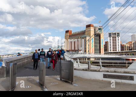 Persone sul Gateshead Millennium Bridge con il Baltic Centre for Contemporary Art alle spalle. Vista da Newcastle upon Tyne, Regno Unito Foto Stock