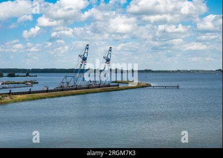 Numansdorp, Olanda meridionale, Paesi Bassi, 4 luglio 2023 - gru industriali e moli presso il fiume Hollandsch Diep Foto Stock