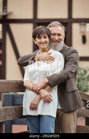 uomo barbuto che abbraccia donna, marito e moglie, romanticismo anziano, felice, popolazione anziana, all'aperto Foto Stock