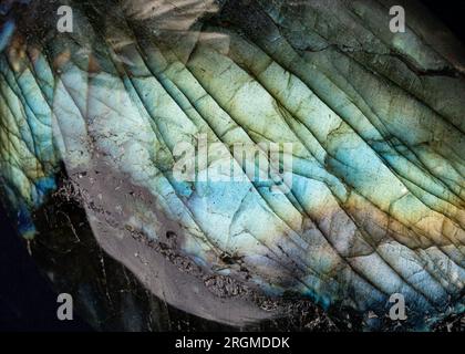 Questa è una foto macro di una pietra labradorita colorata. Ho usato un'illuminazione speciale per far risaltare i colori iridescenti e le texture minerali incrinate. Foto Stock