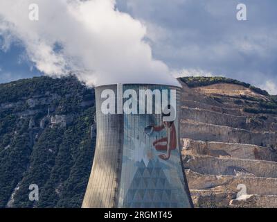 Cruas, Francia - 4 aprile 2023: Vista sul fiume sulla centrale nucleare (CNPE Cruas-Meysse) sullo sfondo di rocce calcaree. Foto Stock