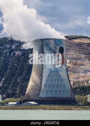 Cruas, Francia - 4 aprile 2023: Vista sul fiume sulla centrale nucleare (CNPE Cruas-Meysse) sullo sfondo di rocce calcaree. Foto Stock