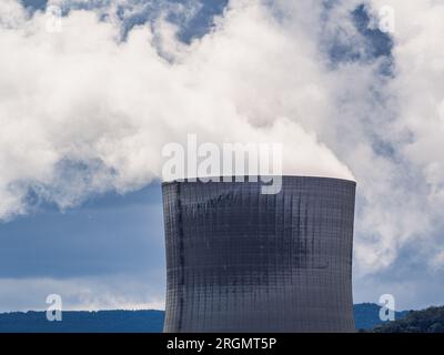 Cruas, Francia - 4 aprile 2023: Vista sul fiume sulla centrale nucleare (CNPE Cruas-Meysse) sullo sfondo di rocce calcaree. Foto Stock