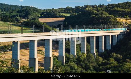 Grane, Francia - 4 agosto 2023: Vista panoramica sul treno passeggeri TGV che attraversa il cavalcavia ferroviario. Vista sulle montagne circostanti in Francia Foto Stock