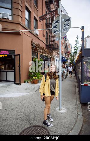 Fan adolescente in posa con l'insegna di Cornelia Street, West Village, in onore della canzone di Taylor Swift. E' l'angolo della sua ex casa a Manhattan, New York. Foto Stock