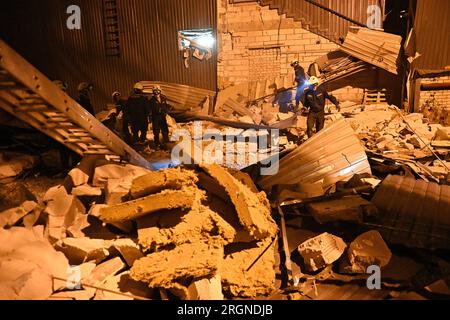 Non esclusiva: ZAPORIZHZHIA, UCRAINA - 9 AGOSTO 2023 - i soccorritori sono visti al lavoro sul luogo di un attacco missilistico russo che ha avuto luogo mercoledì e. Foto Stock