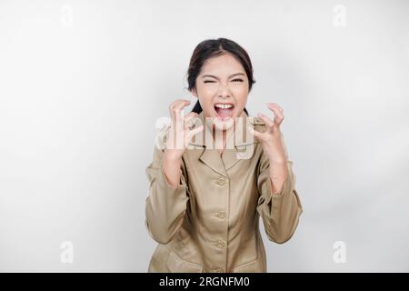 Una lavoratrice civile pazza che indossa un'uniforme marrone è così stressata. Concetto di lavoro eccessivo da parte dei dipendenti governativi indonesiani. Foto Stock