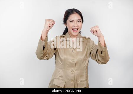 Bella donna asiatica che indossa uniforme che si sente entusiasta. Concetto di successo dei dipendenti governativi indonesiani Foto Stock