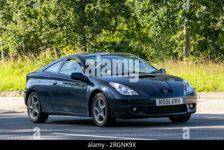 Milton Keynes, Regno Unito - 10 agosto 2023: 2001 auto Toyota Celica nera che guida su una strada di campagna inglese. Foto Stock