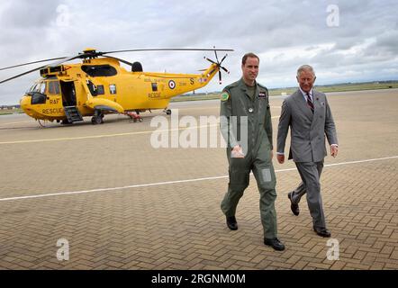 Foto del file datata 09/07/2012 del Duca di Cambridge che mostra il Principe di Galles uno degli elicotteri Sea King che egli detiene mentre il Principe Carlo visita la RAF Valley ad Anglesey, durante il suo annuale tour estivo del Galles. Il re ha rimescolato le nomine militari per i membri della famiglia reale come l'anniversario della morte della defunta regina si avvicina, con tre ruoli extra ciascuno per il principe e la principessa del Galles. Charles ha assunto da solo otto dei precedenti incarichi onorari di sua madre, tra cui lo sponsor della nave da guerra della Royal Navy HMS Queen Elizabeth, e ha condiviso parte della sua stessa pula Foto Stock