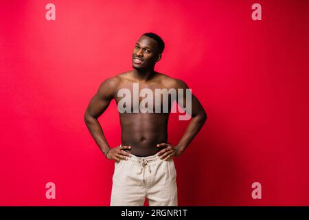 Ridendo un bel giovane africano su sfondo rosso giallo con spazio per le copie Foto Stock