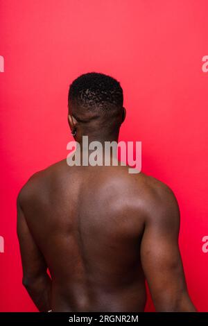 Ridendo un bel giovane africano su sfondo rosso giallo con spazio per le copie Foto Stock