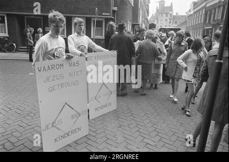 Apertura del Consiglio Mondiale delle Chiese a Domkerk a Utrecht; due giovani in possesso di cartelli ca. 13 agosto 1972 Foto Stock