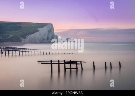 Alba in cielo lilla a Cuckmere Haven e scogliere Seven Sisters sulla costa orientale del Sussex, Inghilterra sud-orientale, Regno Unito Foto Stock