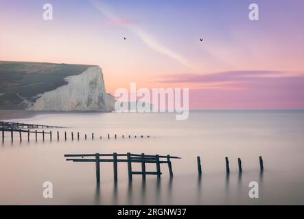 Alba in cielo lilla a Cuckmere Haven e scogliere Seven Sisters sulla costa orientale del Sussex, Inghilterra sud-orientale, Regno Unito Foto Stock