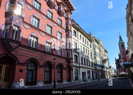 Il Cooperative Business Bank Building (o Vurnik House) e la chiesa francescana in via Miklosich - Lubiana, Slovenia Foto Stock