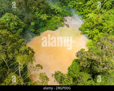 Vista aerea del fumante lago caldo circondato da una foresta verde. Lago AGCO a Kidapawan, Mindanao. Filippine. Concetto di viaggio. Foto Stock