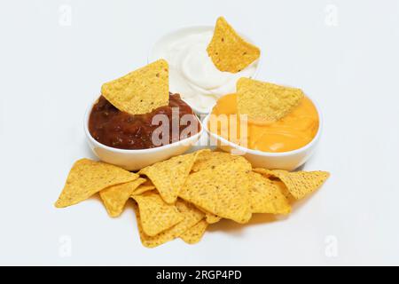 Nachos immergere in salsa al formaggio cheddar alla maionese e salsa Foto Stock