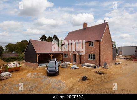 Costruzione di alloggi di lusso di nuova costruzione in costruzione con strade e materiali da costruzione non costruiti Foto Stock