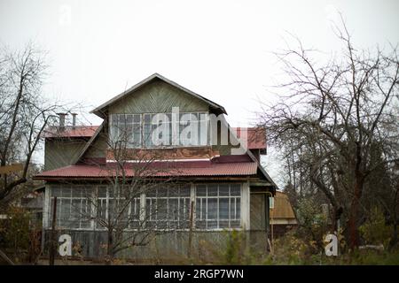 Vecchia casa in campagna. Grande finestra in una casa di legno. Foto Stock