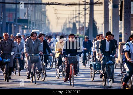 Biciclette e ciclisti all'incrocio stradale, Pechino, Cina Foto Stock