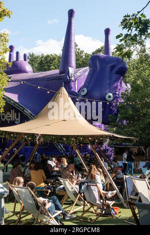 Chi ama le frange sotto un gazebo nei George Square Gardens, di fronte alla grande mucca viola Udderbelly, che è un iconico luogo teatrale di Fringe. Foto Stock