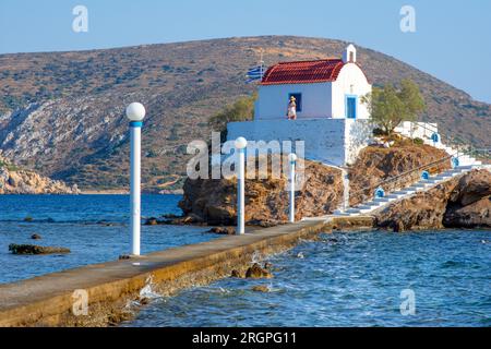 Piccola chiesa di Agios Isidoro nel mare sopra le rocce, isola di Leros, Grecia. Foto Stock