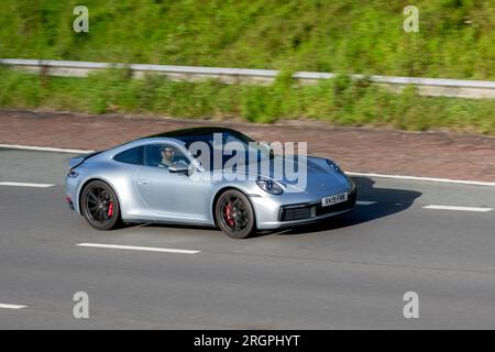 2019 Silver Porsche 911 Carrera S-A; viaggia a velocità sostenuta sull'autostrada M6 a Greater Manchester, Regno Unito Foto Stock